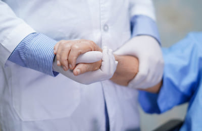 врач держит руку пациента